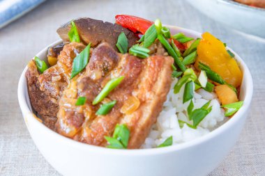 Baharatlı domuz eti ve sebzeli bir kase pirinç - geleneksel Asya yemeği.