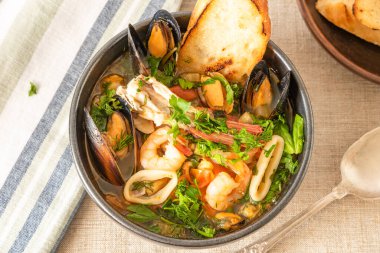Ev yapımı cioppino tost ve tost, üst görünüm - İtalyan-Amerikan deniz ürünleri çorbası - balık, midye, karides ve kalamar.