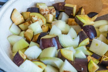 Patlıcan ve soğan büyük bir kırsal tavada kızartılır..