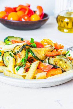 Tabakta Margarita makarnası ve arkada vişneli domates - domatesli makarna, kabak, mozzarella ve fesleğen.