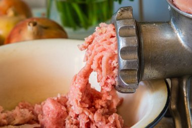 Kırsal arka planda kıyma makinesi ve çiğ et yakın plan.