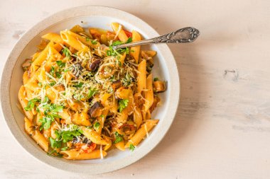 Açık bir kırsal masada tabak üzerinde makarna caponata. Tarif kopyalama alanı