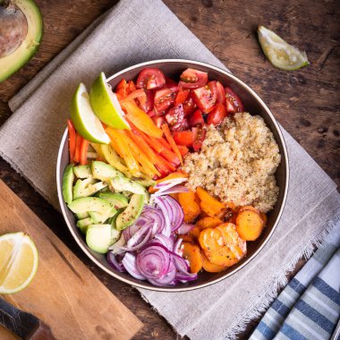 Vejetaryen havuç, biber, avakados, soğan, domates, limon dilimli kinoa salatası.