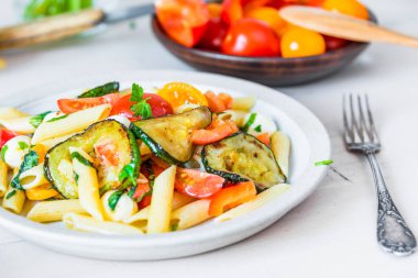 Tabakta Margarita makarnası ve arkada vişneli domates - domatesli makarna, kabak, mozzarella ve fesleğen.