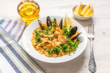 Hafif ahşap arka planda bir tabakta deniz mahsullü risotto - İtalyan mutfağı.