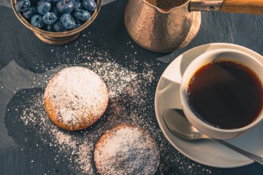 Lezzetli bir kahvaltı. Bir fincan kahve ve yaban mersinli kek.