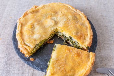 Siyah bir tabakta brokoli ve peynirli dilimlenmiş turta, üst manzara - vejetaryen mutfağı.