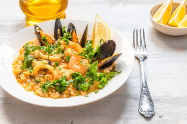 Hafif ahşap arka planda bir tabakta deniz mahsullü risotto - İtalyan mutfağı.