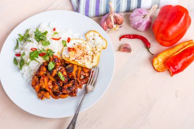 Tayland usulü tavuk, baharatlı soslu tavuk, pilav ve sade arka planda kızarmış yumurta. Üst manzara, kopyalama alanı.