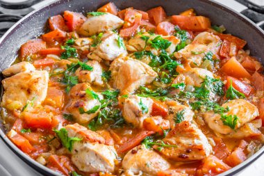 Tavuk cacciatore kızartma tavasında, domatesli tavuk yahnisi ve kırmızı biberle pişirilir.
