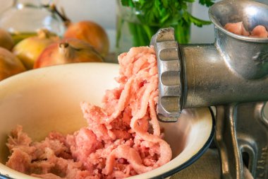 Kırsal arka planda kıyma makinesi ve çiğ et yakın plan.