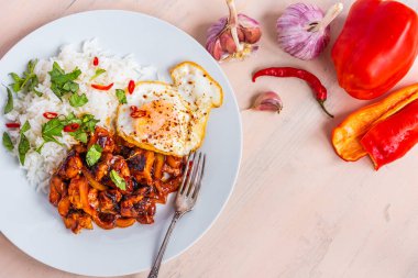 Tayland usulü tavuk, baharatlı soslu tavuk, pilav ve sade arka planda kızarmış yumurta. Üst manzara, kopyalama alanı.