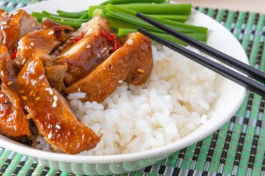 Teriyaki tavuklu bir kase pilav ve yemek çubukları. Asya mutfağı - Japon, Çinli, Koreli.
