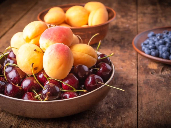 Reife Aprikosen Kirschen Und Blaubeeren Schalen Auf Einem Holztisch — Stockfoto