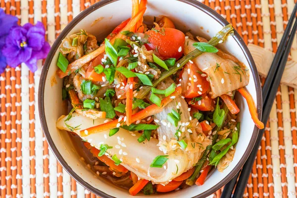 Spicy Asian salad of pickled Chinese cabbage, tomatoes, pepper, green onions and sesame. Kimchi cabbage in a bowl on a bamboo napkin. — Stock Image Spicy Asian Salad Pickled Chinese Cabbage Tomatoes Pepper Green Onions Stock Photo
