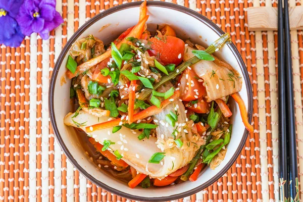 Spicy Asian salad of pickled Chinese cabbage, tomatoes, pepper, green onions and sesame. Kimchi cabbage in a bowl on a bamboo napkin. — Stock Image Spicy Asian Salad Pickled Chinese Cabbage Tomatoes Pepper Green Onions Royalty Free Stock Images