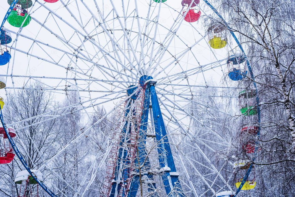 Ferris wheel in the winter park during a snowfall