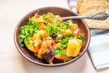 Kırsal bir tabakta sebze kızartma, açık ahşap bir masada durmak - sağlıklı organik bir yemek..