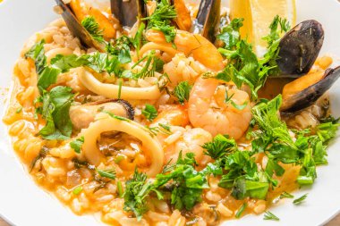 Açık ahşap bir tabakta deniz mahsullü risotto, yakın plan İtalyan mutfağı.