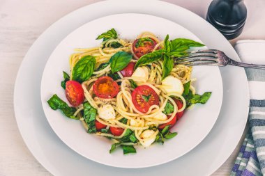 İtalyan yemeği - Spagetti kapuçini yakından çek. Mozzarella, kiraz domates ve fesleğenli makarna.