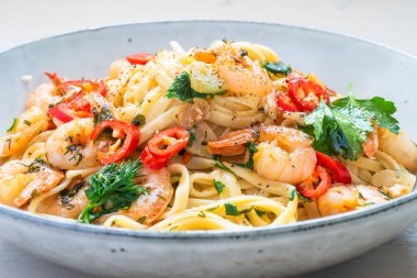 Kırsal bir tabakta karidesli linguine yakın plan - deniz mahsullü geleneksel Akdeniz makarnası, İtalyan mutfağı.