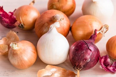 Masada farklı renkte soğanlar - beyaz, kırmızı, sarı