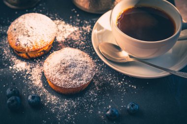 Lezzetli bir kahvaltı. Bir fincan kahve ve yaban mersinli kek.