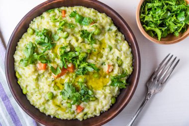 Bezelyeli, havuçlu ve maydanozlu geleneksel İtalyan vejetaryen risotto.