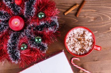 Noel çelengi çok renkli süs, mum, şekerli kakao ve açık bir kitaptan yapılmıştır. Kopya alanı.