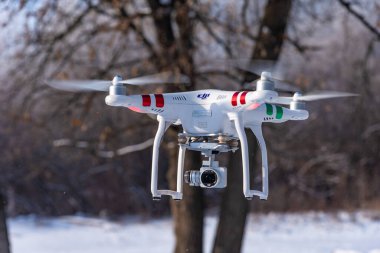 Engels, Rusya - 1 Aralık 2018: Video kameralı drone Phantom kışın ormanda uçuyor. Kameralı dörtgen.