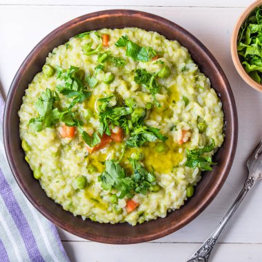 Bezelyeli, havuçlu ve maydanozlu geleneksel İtalyan vejetaryen risotto.