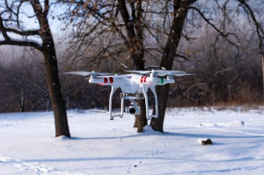 Engels, Rusya - 1 Aralık 2018: Video kameralı drone Phantom kışın ormanda uçuyor. Kameralı dörtgen.