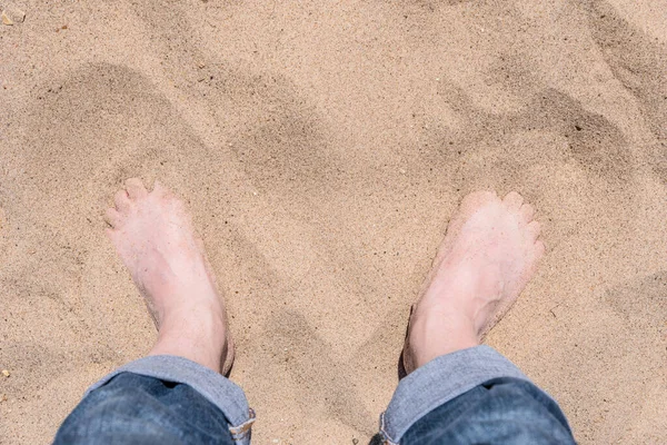 男人的腿 沙子里穿着牛仔裤 — 图库照片