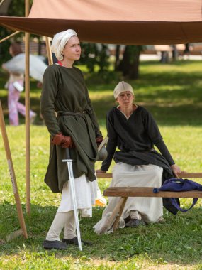 Moskova, Rusya, 8 Haziran 2019 Ortaçağ giysileri içindeki genç bir kadın kısa bir kılıçla ayakta duruyor. Ortaçağ yaşamının yeniden inşası