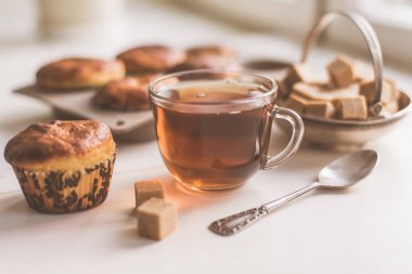 Bir bardak çay ve taze pişmiş çörekler masada - doğal ışık