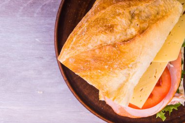 Jambonlu, peynirli, marullu, soğanlı ve domatesli sandviç.