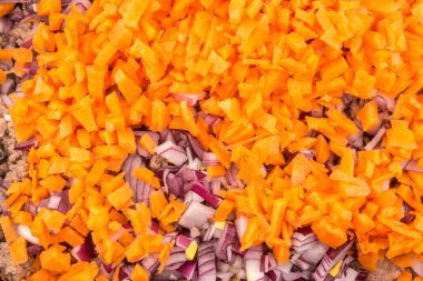 Bolonez sosu için soğan ve havuçla doldurulmuş et kızartma tavasında kızartılır. Yakın plan.