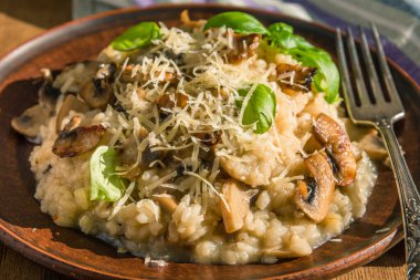 İtalyan yemeği - Fesleğen yapraklı vejetaryen mantarlı risotto ve Naprostovatom köyü masasında parmesan peyniri.