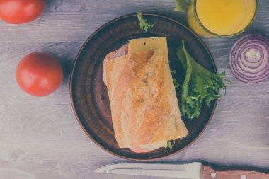 Jambonlu, peynirli, marullu, soğanlı ve domatesli taze sandviç.