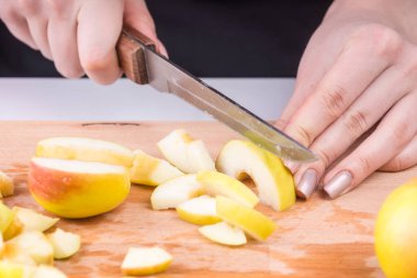 Kadın eli, elmalı pasta için elmayı parçalara ayırır.