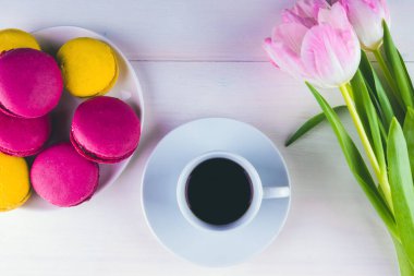 Bir fincan kahve, bir buket çiçek ve arka planda kek - üst manzara. Sevgililer Günü 'nde tebrikler.