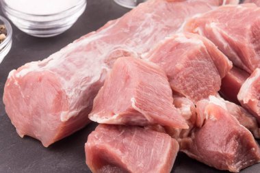 Çiğ domuz filetosu yakın çekim ve söndürmek için doğranmış et parçaları.