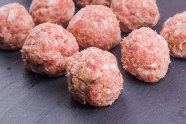 Koyu arkaplanlı taze çiğ et topları.