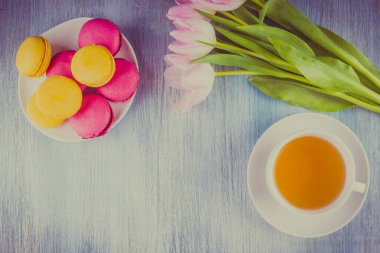 Kurabiyeler, çay ve ahşap arka planda bir buket lale. Kopya alanı. Sevgililer Günü için tebrik ederim.