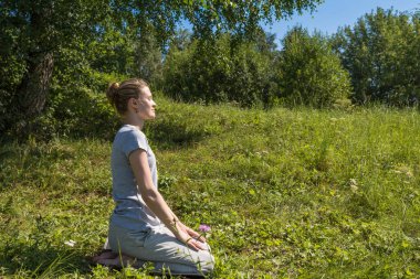 Genç ve çekici bir kadın güneşli bir günde doğada dinleniyor.