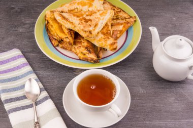 Lezzetli altın üçgen puf böreği masada ve bir fincan çay - üst manzara