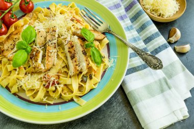 Geleneksel İtalyan tagliatelle makarnası, büyük bir tabakta vişneli domates ve kızarmış tavuk.
