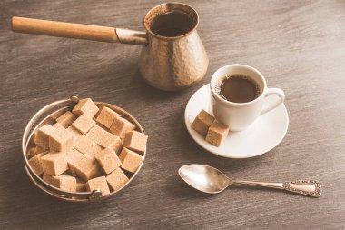 Masada bir fincan kahve, Türk kahvesi demliği ve kamış şekeri