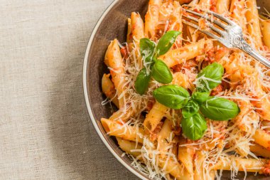 Makarna All 'Arrabbiata, geleneksel İtalyan yemeği. Köy tabaklarında domates soslu ve fesleğenli makarna. Yakın plan.