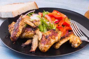 Köy usulü kızarmış tavuk kanadı, salata ve ekmek.
